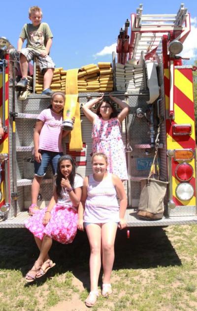 Aiden Melo sits atop the firetruck while Alexis Coe (left), Jayla Fernandes (bottom left), Patricia Spillane (bottom right) and Gabriella Hermanson (right) pose for a picture. BY ZARRIN TASNIM AHMED