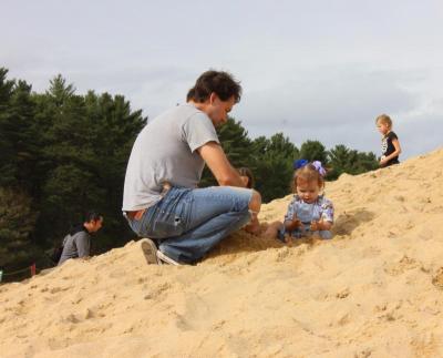 Chris Croteau of Whitman plays with his 18-month-old daughter Teaghan in a massive sand pile. BY MATTHEW BERNAT
