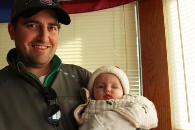 Brian Bishop holds his five-month-old daughter, Addison, who wears a little Santa hat. BY ZARRIN TASNIM AHMED