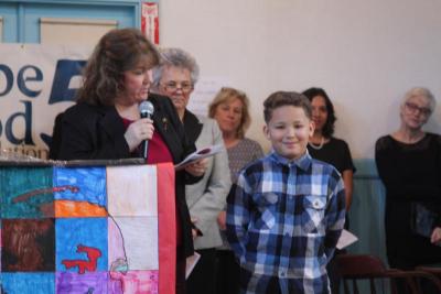 Rija Rakotoarimanitra-Bunting listens as Minot Forest School Principal Joan Seamans explains why he earned a Spirit Award. BY MATTHEW BERNAT