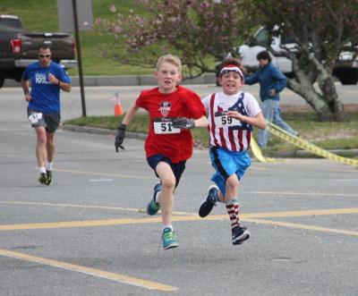 Jackson Veugen, 10, of Wareham (left) and Scott Brodie, 11, of Buzzards Bay, sprint toward the finish on Saturday. The duo was neck and neck for the entire race. BY MATTHEW BERNAT