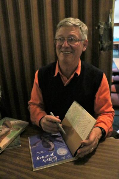 After the presentation, Dr. Rob Bierregaard sold and signed "Belle's Journey," an illustrated book about the migration of an osprey. Photo by: Nadya Korytnikova