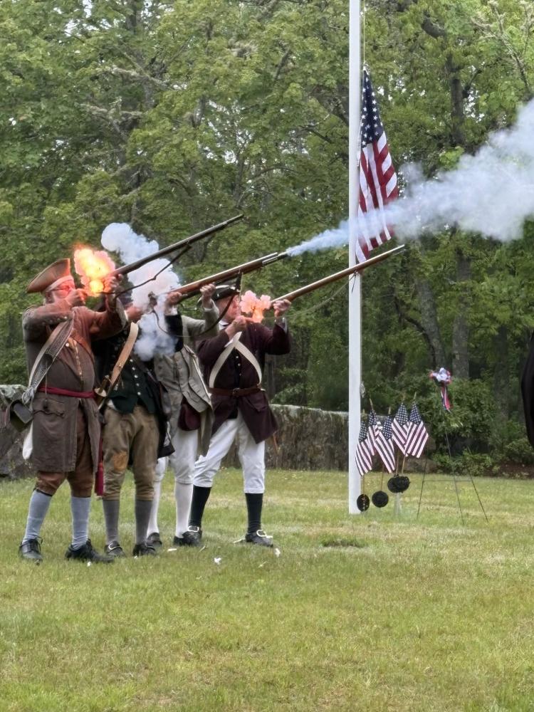 The Minutemen and Militia shoot guns dressed in period clothing.