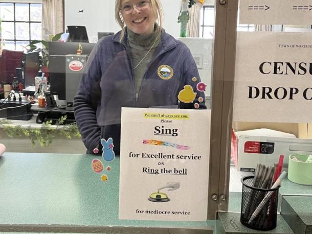  Assistant Town Clerk Shayne Martin and the sign she added pizzaz to with stickers and icons. Photos by Brandy Muz