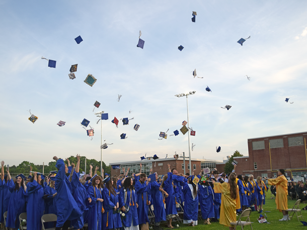 The graduates tossing their caps in the air. Photos by Kat Sheridan