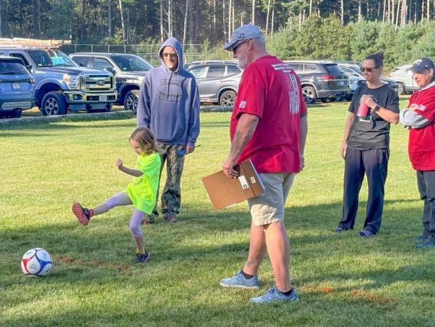 A Youth Soccer player hits a shot while Elks volunteers watch on. Photos by Jim Callan