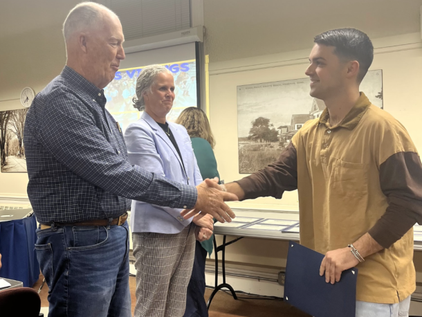 Special education teacher Cameron Decas shakes School Committee Chair Geoffrey Swett's hand. Photos by Tanvi Kulkarni