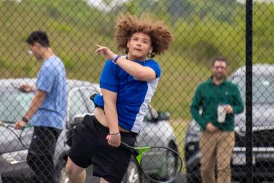 Rija Bunting serves as he wins the last high school tennis set he will ever play.