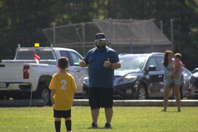 Coach Adam Alexander gives a thumbs up to his team