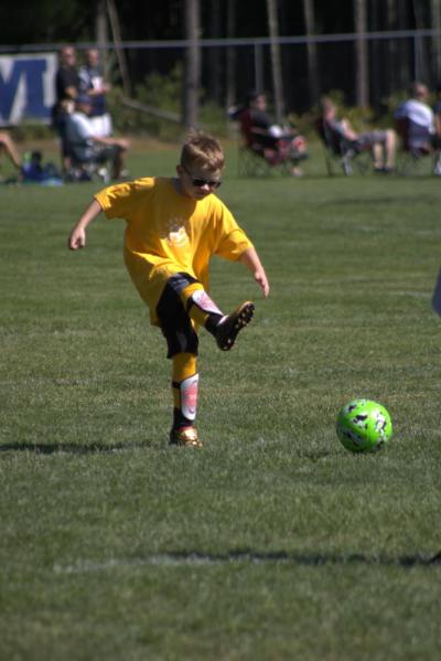 A gold team member kicks toward the goal
