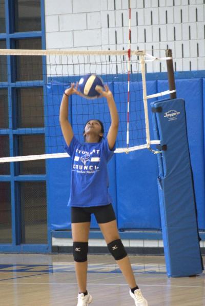 Reaching high, Siya Patel connects with the ball