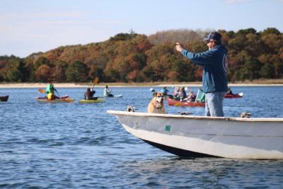 A spectator grabs photos of the paddlers.