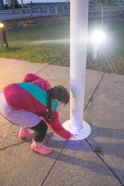 Ainslee Manduca places a light at the flag pole.