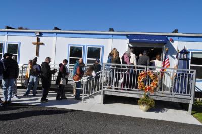 Members file inside the new building.