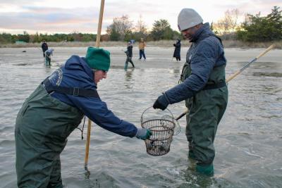 Two event-goers help each other out in the water.