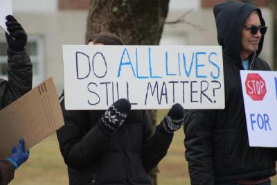 The protest is peaceful with both sides waving signs and chants being called out.