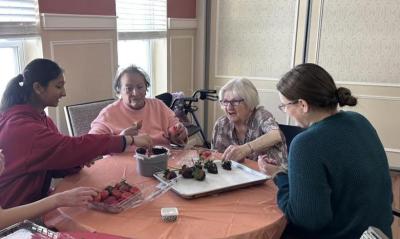 Students work to decorate the strawberries with residents. Photos source: Wareham High School
