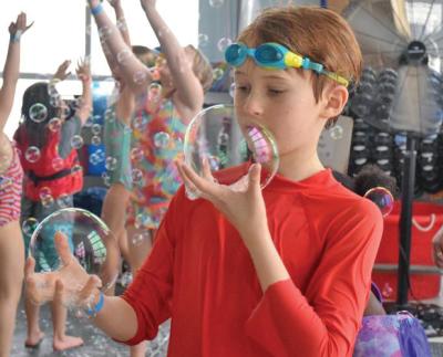 A boy inspects some of the bubbles he caught. 