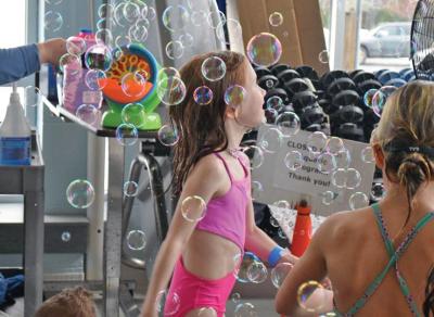 A girl dances in a cloud of bubbles.