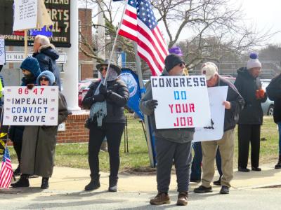 Signs call for Trump's removal and a congressional response to current policy. 