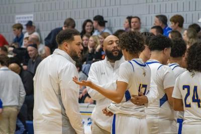 The coaching staff take a player aside during a timeout. 