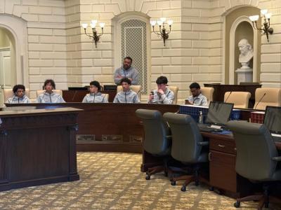 The team listens to Dooner speak on the floor.