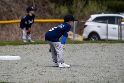 Players on the Farm division wait for the pitch. 