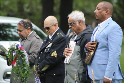 A line of veterans take off their caps during the pledge of allegiance. 