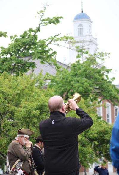 Christopher Berg plays Taps in front of Town Hall.