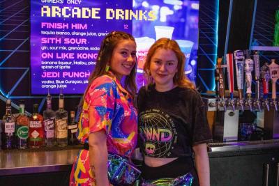 Olivia Vaccaro and Lily Shepley working donned in 80's gear.
