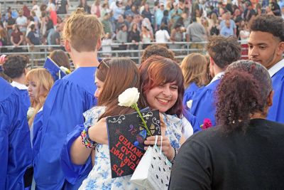 A graduate hugs their friend. 