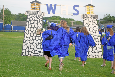 Two graduates skip off into the sunset. 