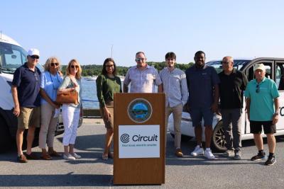 A group of attendees stand for a photo on Onset Pier before cutting the ribbon on the shuttle service.