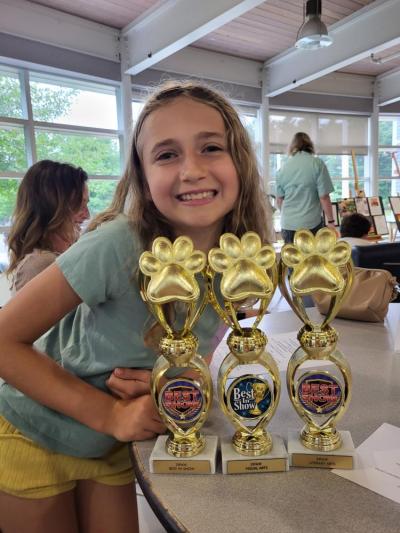 Nova Lomp with her three trophies for artwork, writing and "best in show."