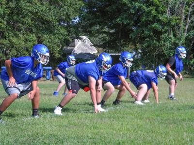 The offensive line practices their stances and footwork. Photo by Christian Uva