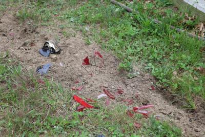 Scattered, shattered pieces of car lights sit in the lawn behind the 7-Eleven. 