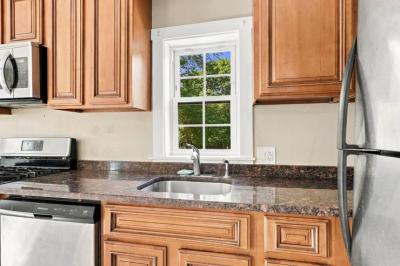 Kitchen sink under a window with granite counters at 17 Beeden Road in Westport, MA