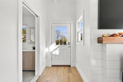 Bright entry hall with new light wood flooring and a view into the updated bathroom at 226 Sanford Road, Westport