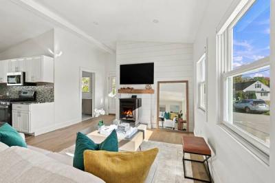Open living room with a lit pellet stove, looking toward the renovated kitchen at 226 Sanford Road, Westport