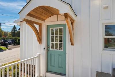 Teal entry door under a curved cedar front portico at 226 Sanford Road, Westport, MA