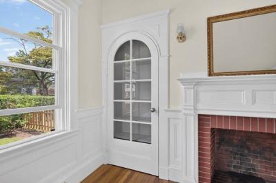 Original arched glass-paned door beside the fireplace in Unit 1, 370 Maple Street, New Bedford