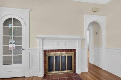 Brick fireplace with a white mantel and arched doorway in Unit 2 at 370 Maple Street, New Bedford, MA