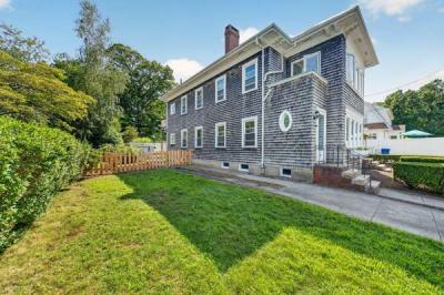Side yard with lawn and a wooden fence beside 370 Maple Street, New Bedford, MA