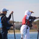 Instead of searching for French fries this seagull leads a paddleboard.
