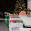 An elf donates to Toys for Tots.