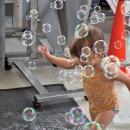 A child runs through the bubbles. 