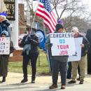 Signs call for Trump's removal and a congressional response to current policy. 