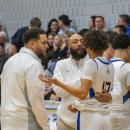 The coaching staff take a player aside during a timeout. 