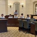 The team listens to Dooner speak on the floor.