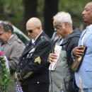 A line of veterans take off their caps during the pledge of allegiance. 